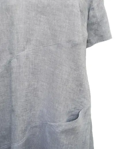 Graues Leinenkleid mit feiner Struktur, sichtbaren Nähten und seitlicher Eingrifftasche aus Naturstoff in schlichter, lockerer Passform.